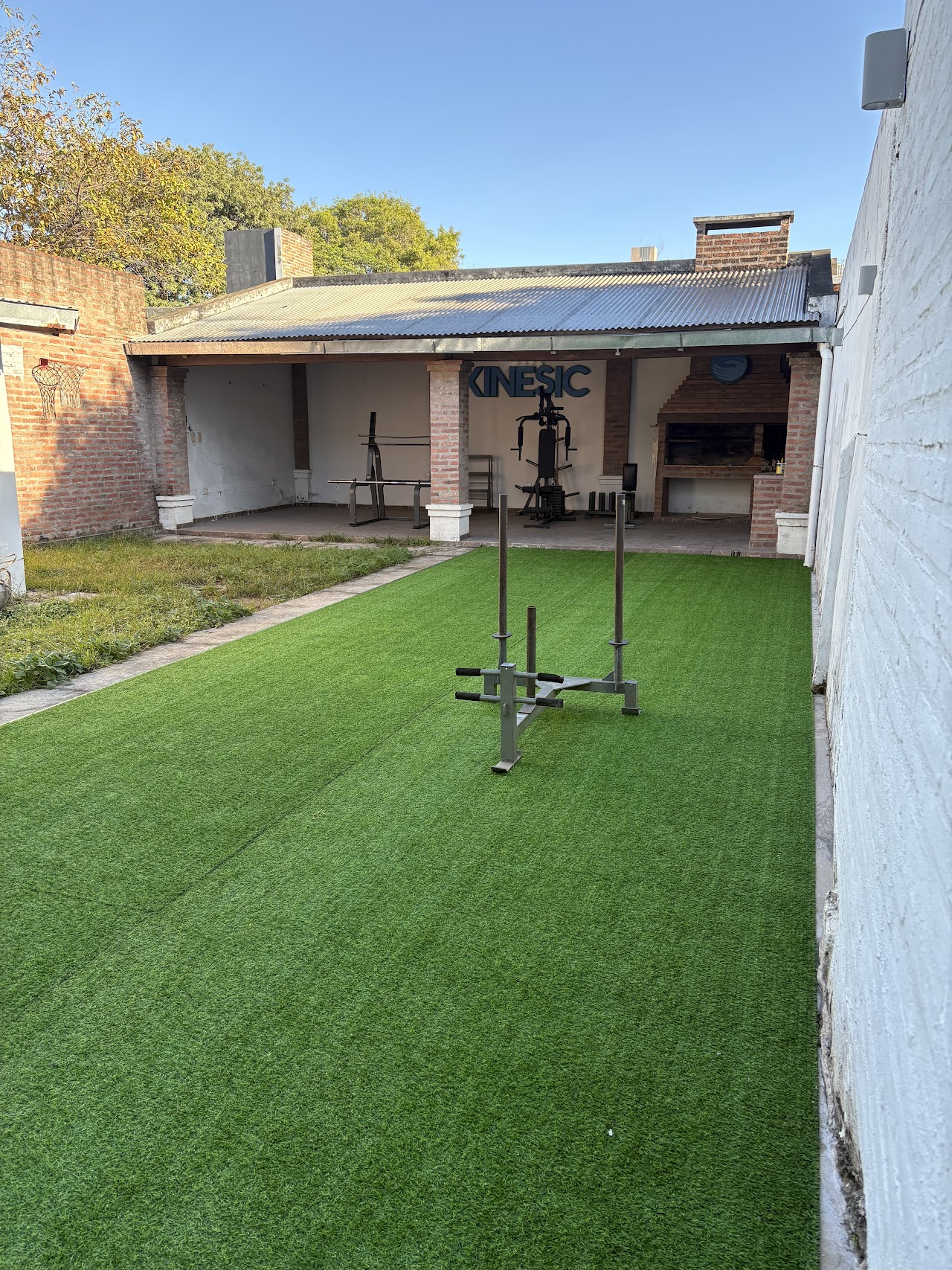 Patio con césped sintético de KINESIC para ejercicios al aire libre